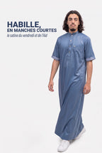 Homme en marche portant le qamis saoudien satiné Musa bleu marine, le satiné en manches courtes