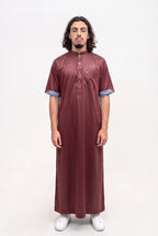 Qamis saoudien satiné Musa bordeaux porté, col mao et manches courtes, sur fond blanc