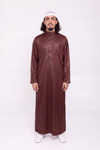 Qamis saoudien Omar bordeaux satiné porté, col mao et poche poitrine, sur fond blanc