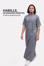 Homme en marche portant le qamis saoudien satiné Musa gris, le satiné en manches courtes