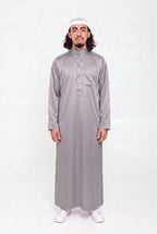 Qamis saoudien satiné Omar gris porté, col mao et poche poitrine, sur fond blanc