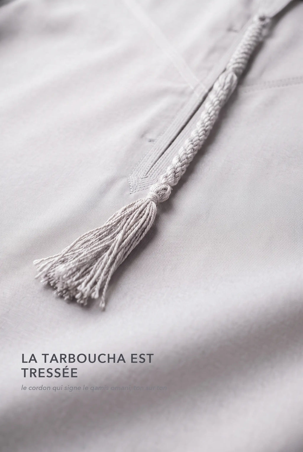 Macro de la tarboucha blanc cassé du qamis omani Hamza, cordon tressé ton sur ton